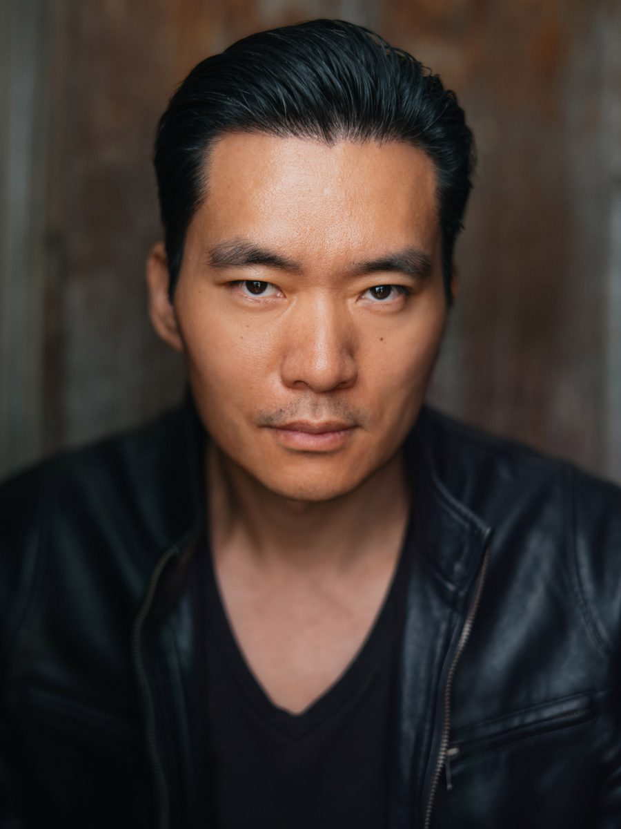 Headshot of Young-H. Lee in a black leather jacket, looking straight at the camera