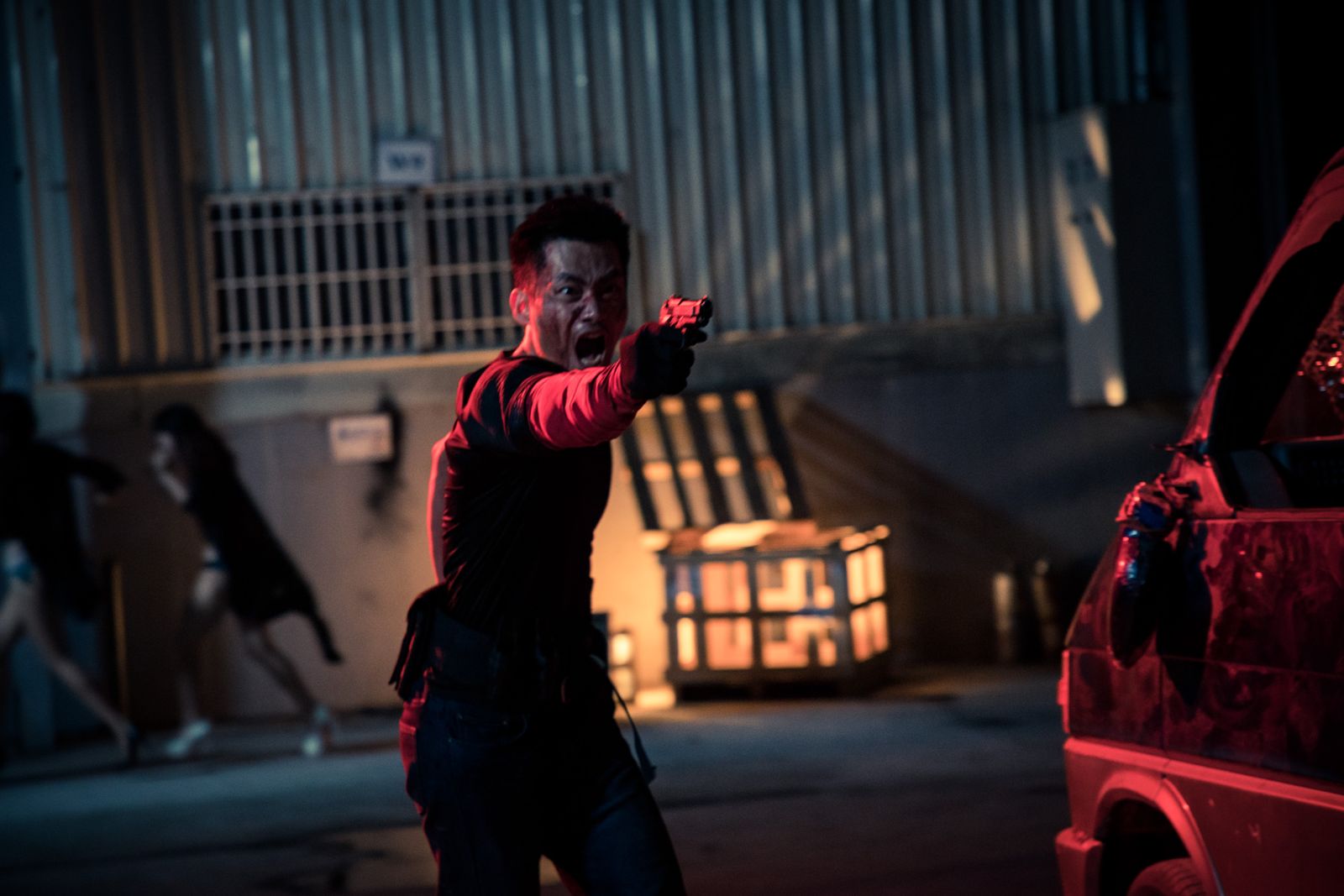 Kuang Feng aiming a pistol, lit in red