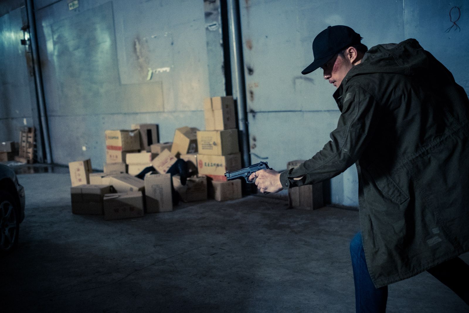 Kuang Feng advancing through a warehouse with a pistol